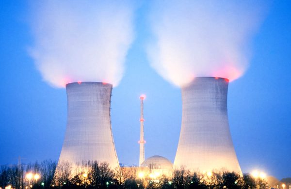 Nuclear power plant blowing huge clouds into sky at dusk just after sunset