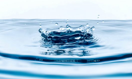 closeup of water drops falling in the glass