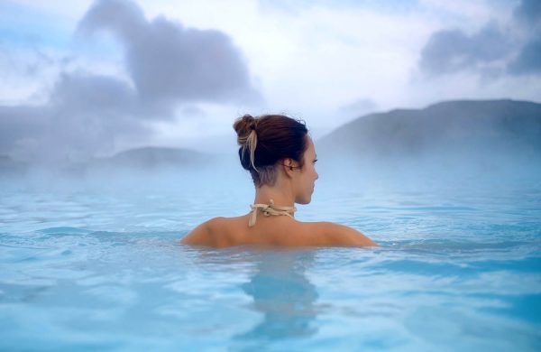 Woman enjoys spa in geothermal hot spring .